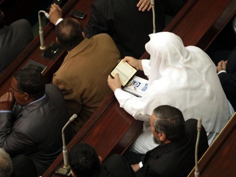 A member of parliament reads the Koran before the start of the first Egyptian parliament session