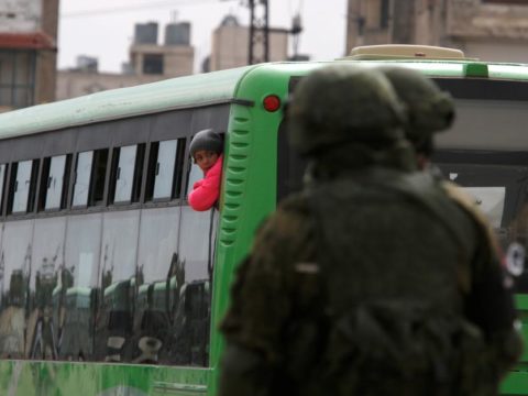 A boy rides a bus to evacuate the besieged Waer district in the central Syrian city of Homs